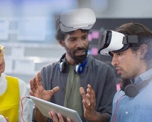 Computer programmers with digital tablet programming virtual reality simulators