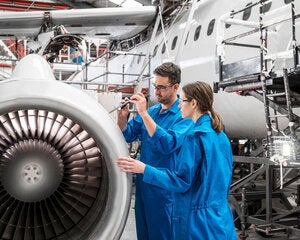 Workers using traditional tools manufacturing aircraft