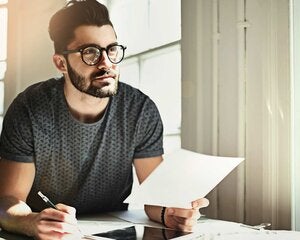 man writing at table