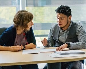 Counseling appointment for young latino man student in counsellor College office.