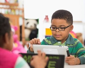 Students using digital tablet in classroom
