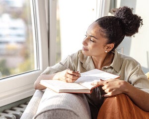 woman writing by the window