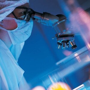 laboratory worker looking into a microscope