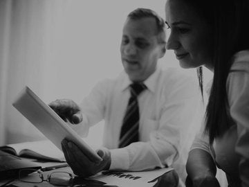 Man and woman reviewing data on tablet