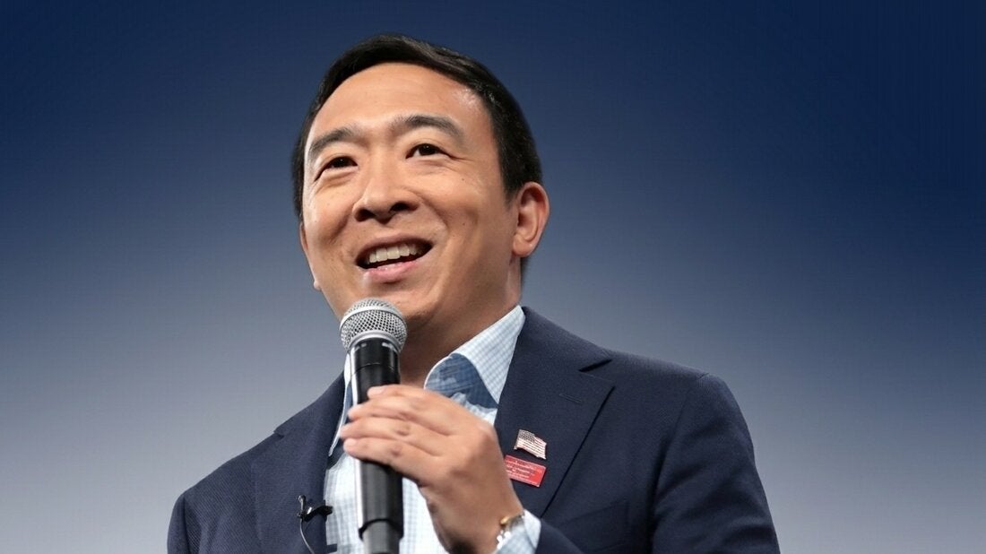 Andrew Yang speaks into microphone