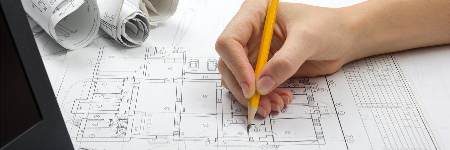 Architect making notes on autocad printout of floorplan.