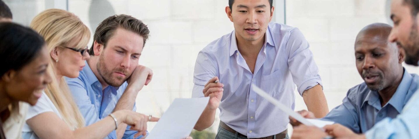 Accountings discussing financials around a table.