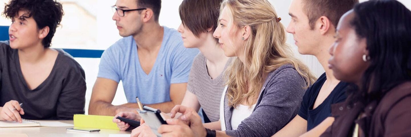 Group of writing students in a classroom