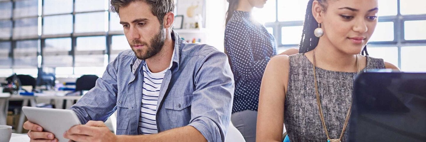 Young workers in office working on tablets and computers