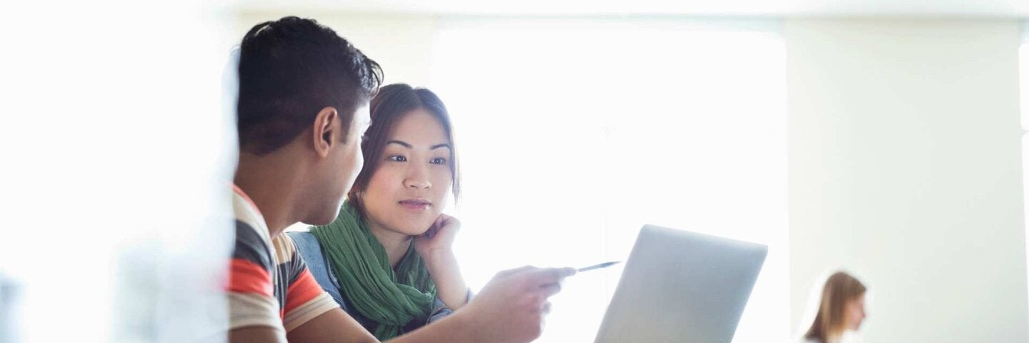 Students discussion what's on a laptop screen