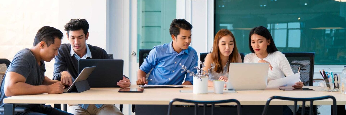 Team of young entrepreneurs sat around a table having a meeting.