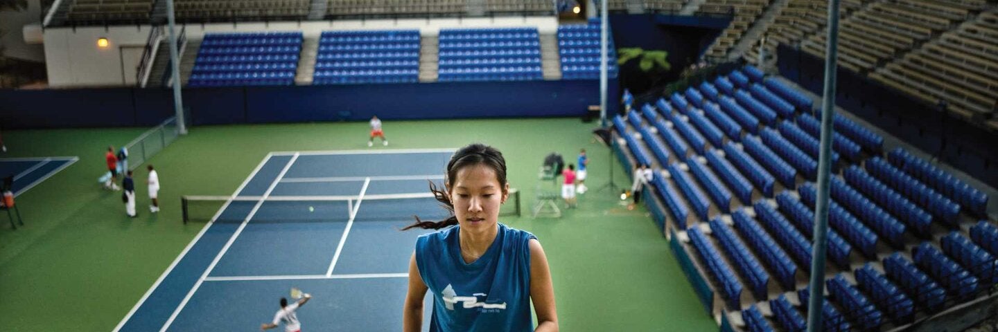 Student running up steps of the campus' Los Angeles Tennis Center