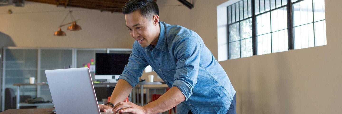 Mixed race businessman working on laptop in office
