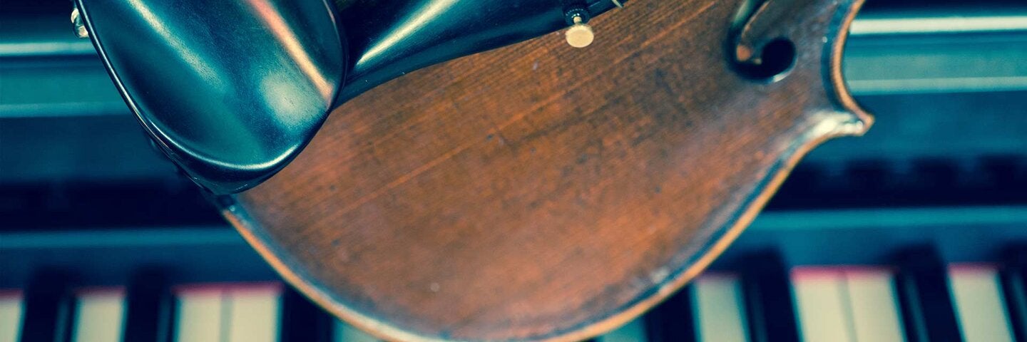 Close-Up Of Violin On Piano Keys