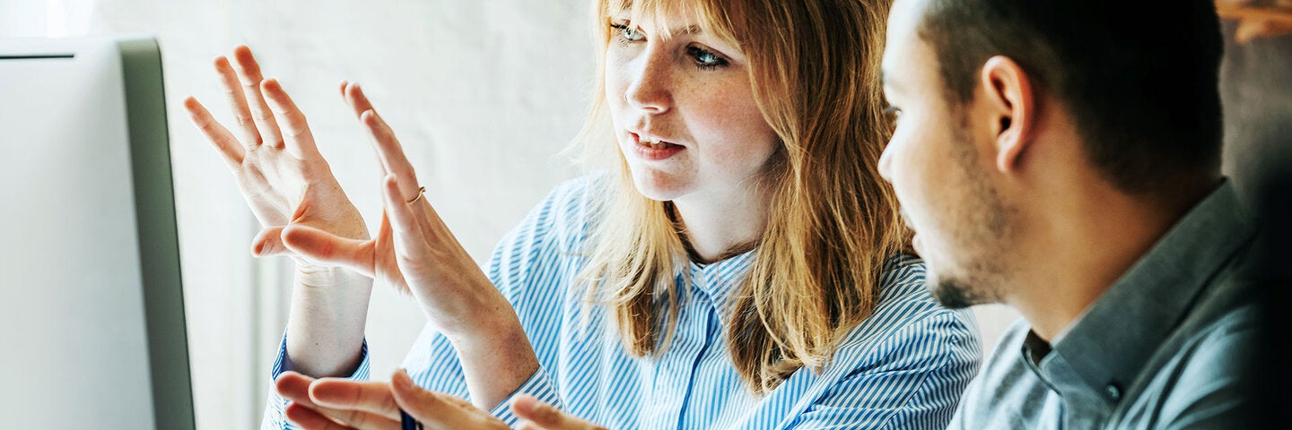two professionals talking and looking at a computer screen