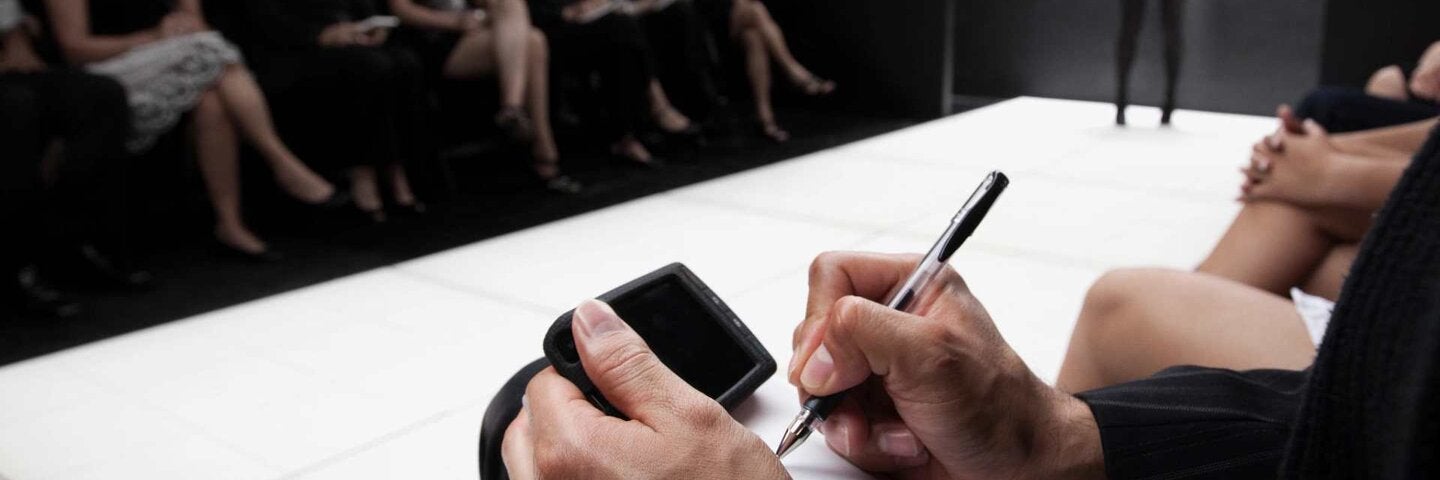 Critic writing a review at a fashion show