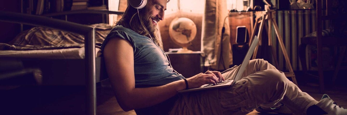 Man using a laptop with headphones