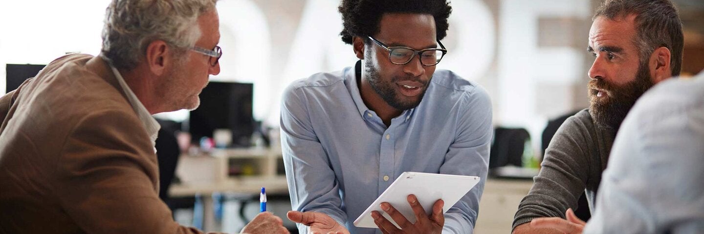 Businessman presenting to co-workers with tablet