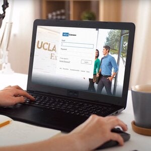 student logging into canvas using a laptop