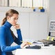 female accountant in blue sweater using calculator